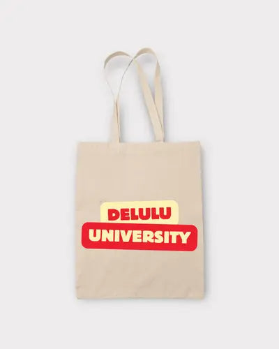 Beige tote bag with 'DELULU UNIVERSITY' text on a white background