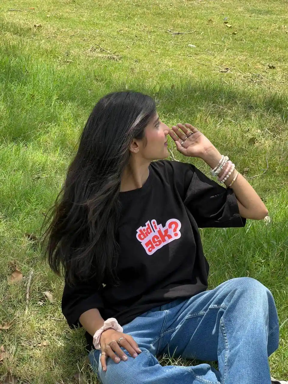 A woman wearing a black graphic t-shirt with the text 'did i ask?'