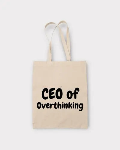 Beige tote bag with 'CEO of Overthinking' text on a white background