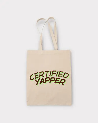 Beige tote bag with 'CERTIFIED YAPPER' text on a white background